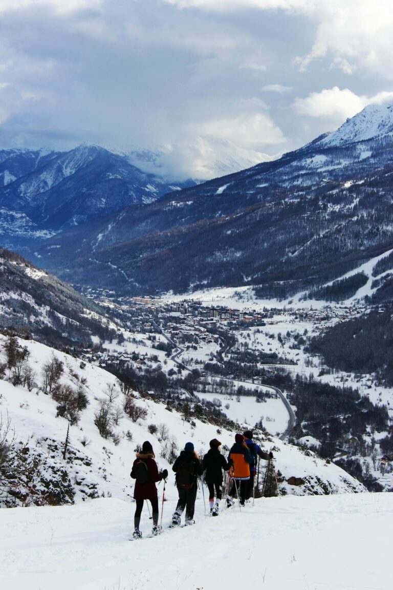 A group of people skiing in high altitude snowy mountains, enjoying winter adventure.