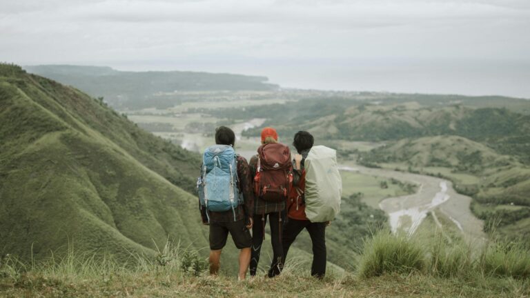 Three friends enjoy a scenic hiking experience in the lush mountains of Bicol, Philippines.