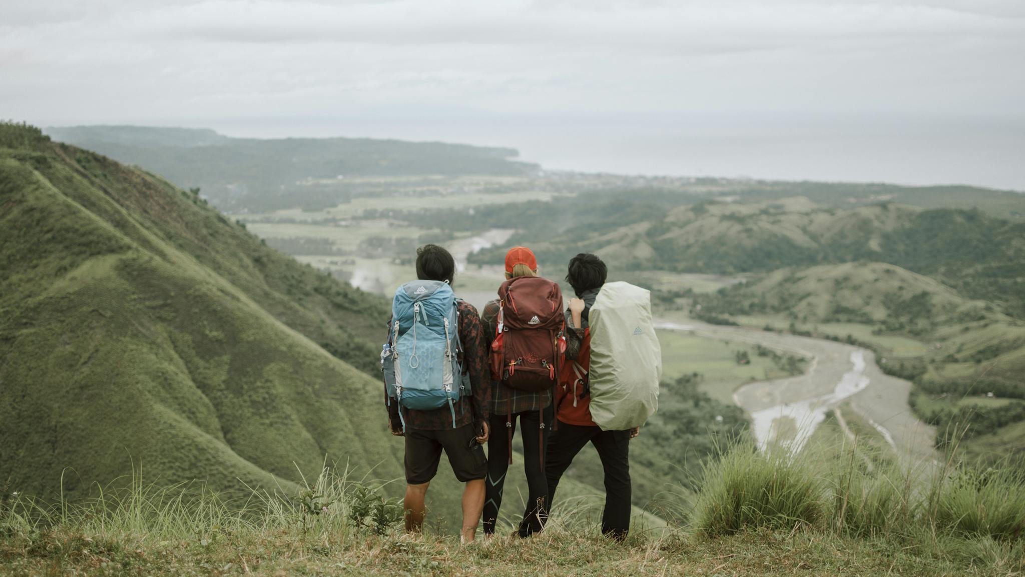 Three friends enjoy a scenic hiking experience in the lush mountains of Bicol, Philippines.
